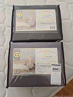 Two unopened Lavish Hotel Luxury 9900 Series queen sheet sets in original packaging