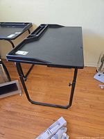Overall view of black plastic adjustable table on steel frame