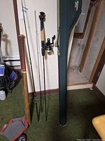 Fishing rod sections, reel, bat, rod case visible
