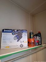 Group shot showing Michelin inflator box, Raid aerosol, leather cream tub, motor-oil bottle