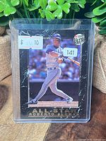 Front of card in protective sleeve showing Roberto Alomar batting, price and lot stickers visible