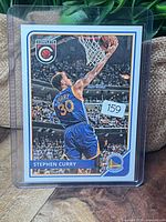 Front of sleeved Stephen Curry Panini Complete card