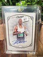 Front of autographed Damian Warner Champ's card in holder