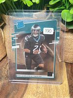 Front view of Jalen Hurts Rated Rookie acetate card in plastic top loader with price sticker