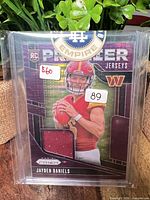 Front of the 2024 Panini Prizm Premier Jerseys Purple Power Jayden Daniels rookie card in sleeve