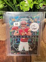 Front view of the Jayden Daniels Prizmatic parallel card in sleeve and top-loader
