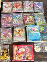 Grid of sleeved Pokémon V cards, common cards, dice, counters, sleeves visible