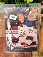 Front of card in plastic sleeve showing player image, name, team, date and highlight
