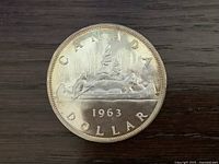 Reverse of 1963 Canadian silver dollar showing canoe design