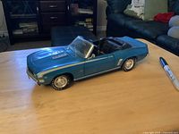 Full side view of blue 1969 Camaro diecast convertible on table