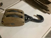 Full view of wooden pulley block with iron hook