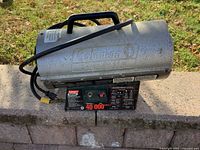 Full view of Coleman Powermate heater showing cylindrical body and handle