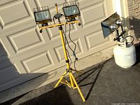 Full view of yellow tripod work light with two halogen heads