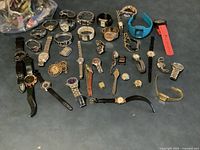 All wristwatches and parts laid out on blue surface