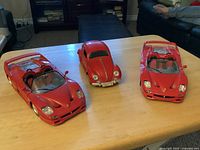 Front angled view of two Ferrari F50s and Volkswagen Beetle