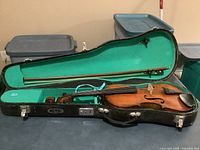 Violin inside open hard shell case with bow