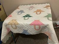 Full view of quilt on table showing basket blocks and border
