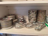 Stacked rice bowls, soup spoons, teacups and shallow bowls on shelf