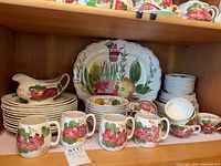 Full set on shelf showing platter, gravy boat, plates, mugs, bowls