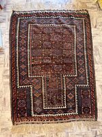 Full view of hand-knotted geometric wool rug showing entire pattern and fringe
