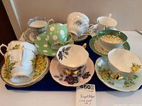 Group of assorted teacup and saucer sets showing fronts and floral/polka-dot designs