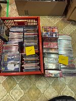 Two crates filled with stacked new CDs, yellow notes reading "New" visible