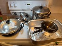 All cookware grouped on stove and roaster pan