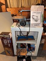 Scroll saw on stand with mitre box box visible