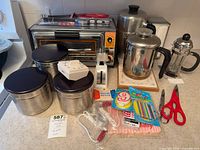 Overall lot showing toaster oven, three canisters, coffee pots, French press and small accessories