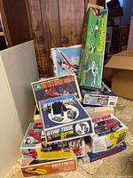 Stacked view of multiple vintage boxed model kits and toy sets