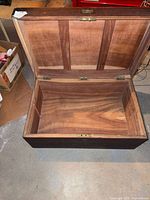 Open trunk showing interior wood, hinges and latch