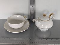 Teapot, cup and saucer grouped with rulers for scale