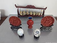 Full lot: plaques on stands, vase, eggs on stands, chimes on rack