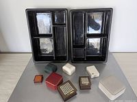 Overall view showing two black display trays and nine closed jewelry boxes