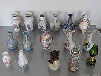 Full group of 16 miniature vases, stein and oil lamp on table
