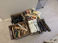Four boxes containing assorted plastic, wooden and velvet-style adult hangers