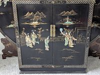 Front view closed showing relief figures, brass hardware, gilt decoration