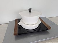 two stacked white casseroles on black tray