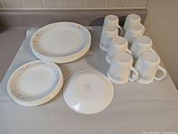 Full set showing dinner plates, salad plates, mugs, one plate bottom with stamp