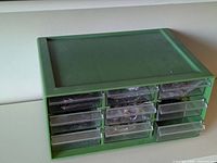 Front view of green plastic organizer with 12 clear drawers