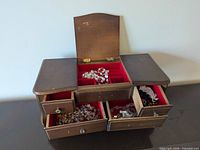 Wood jewelry box open showing drawers and contents
