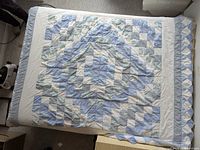 Full view of quilt laid flat on bed, showing overall pattern