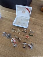 Full layout of cufflinks, tie clips, lapel pins and open Hickok box