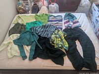 All 12 sweaters and tops laid out on bed