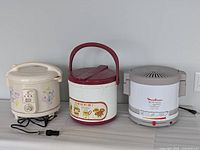 Front view of all three rice cookers showing exteriors and cords