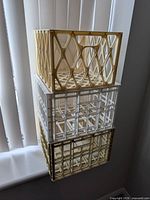 Three stacked plastic milk crates showing diamond and grid patterns
