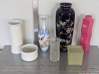 Group shot of all seven vases/holders with rulers for scale