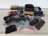 Overview of fifteen pairs eyewear with cases on table