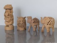 Group view of all four carved wooden figures