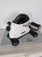 Right side view showing TODO logo, resistance knob, pedals, stabilizer bars